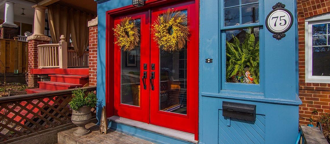 Colourful home entrance with bright red double doors and blue trim